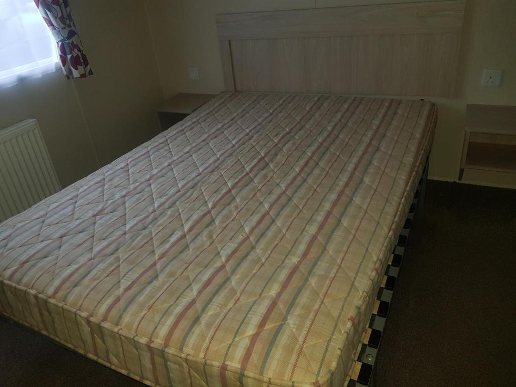 een bed in een kleine kamer met bij 6 Berth on John Fowlers (Sandy Glade) Brean in Berrow