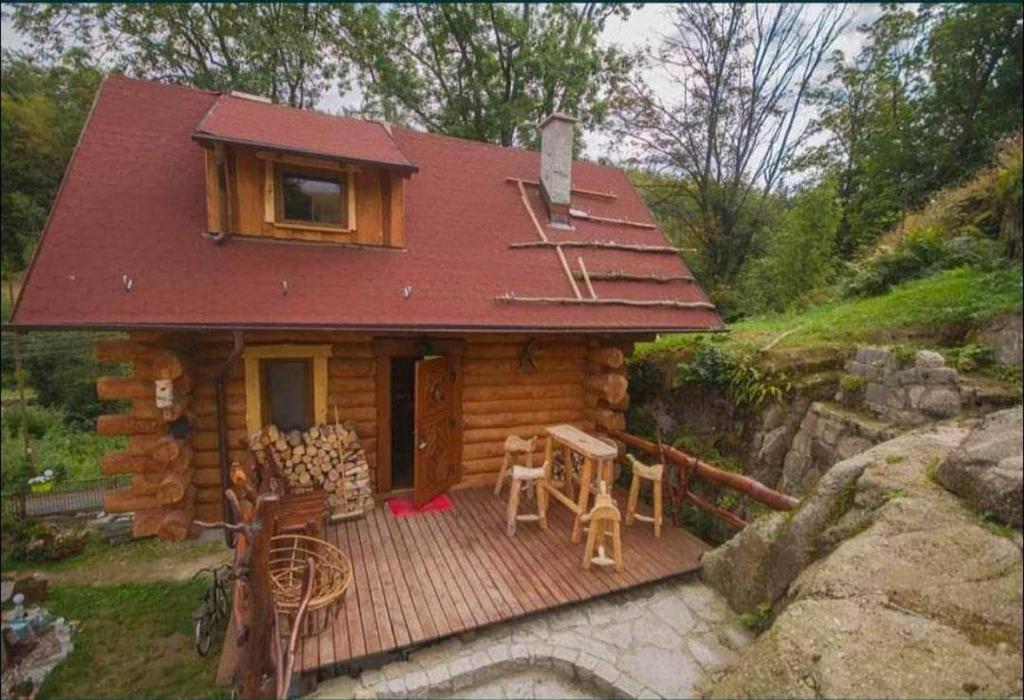 Cabaña de madera con terraza con mesa y sillas en Wysokie Bale Kwatery Jagniatków, en Jelenia Góra