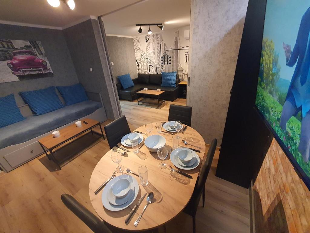 una mesa y sillas en una habitación con sala de estar. en JDK Apartamenty Młynarska 44m2 6-osobowy, en Kalisz