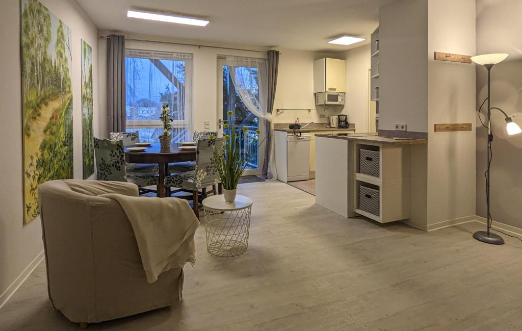 Il comprend une cuisine et un salon avec une table et une chaise. dans l'établissement Ferienwohnung Einraum Apartment Pusteblume, à Eilenburg