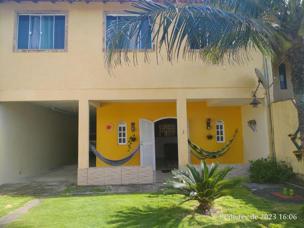 a house with two hammocks in front of it at Hostel Unamar in Cabo Frio