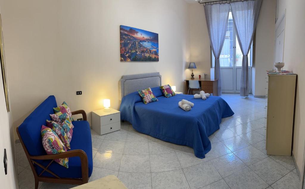 um quarto com uma cama azul e uma cadeira azul em Dimora San Ferdinando em Nápoles