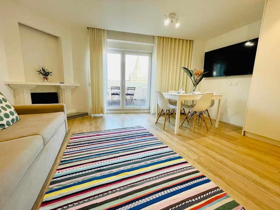 a living room with a couch and a dining room table at Sweet Apartments Downtown in Vila Nova de Famalicão