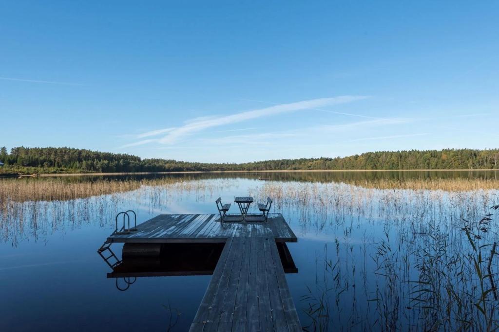 a picnic table on a dock on a lake at The Solhem Cabin in Strömstad