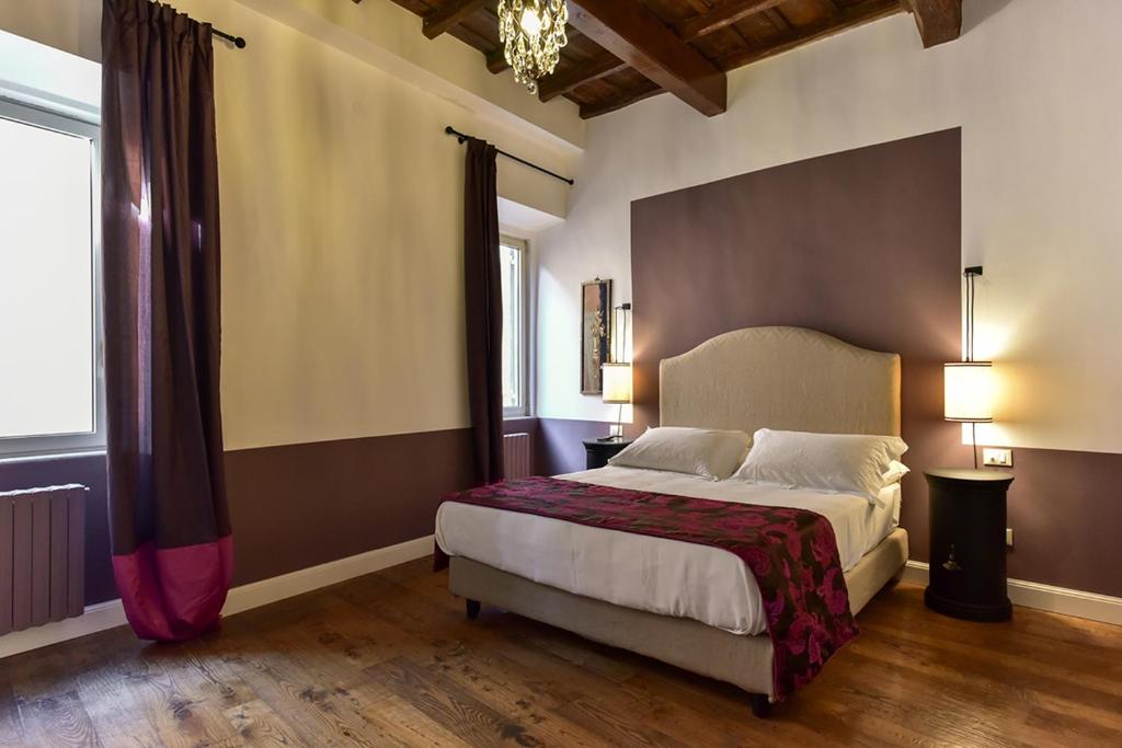 Residenza Clodio Spanish Steps في روما: غرفة نوم بسرير كبير ونافذة كبيرة