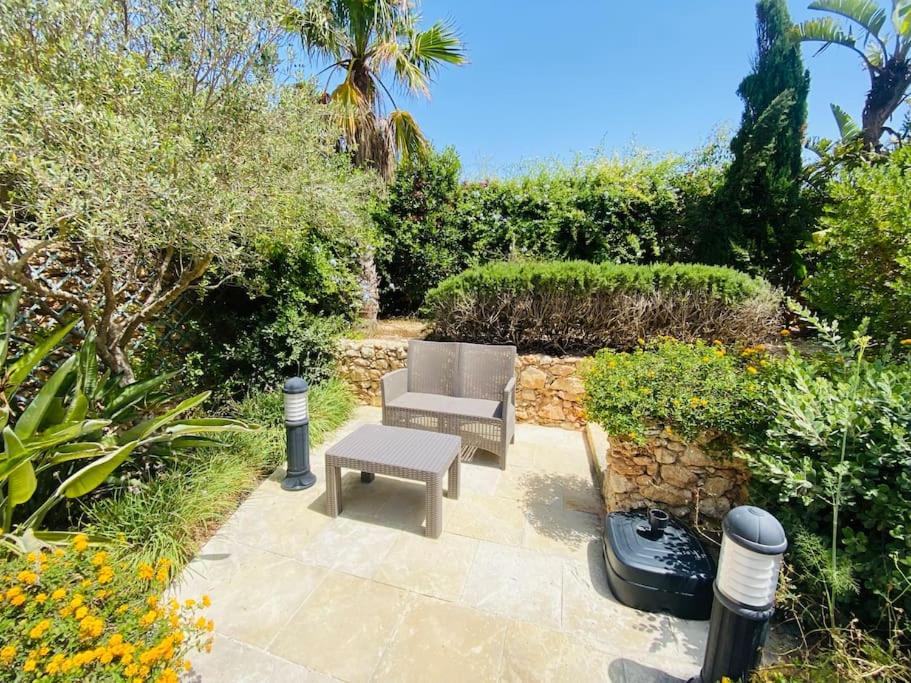 eine Terrasse mit einem Stuhl und einem Tisch und einigen Büschen in der Unterkunft Ta' Klementa Farmhouse in Għarb