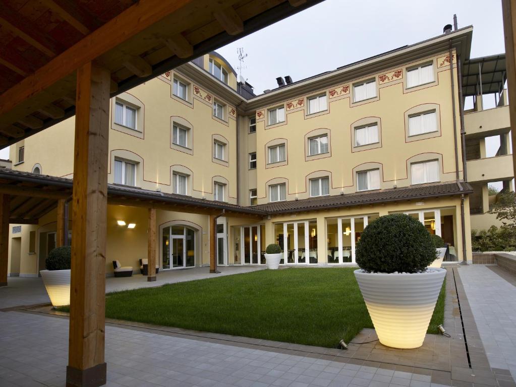 an exterior view of a building with a courtyard at Virginia Palace Hotel in Garbagnate Milanese