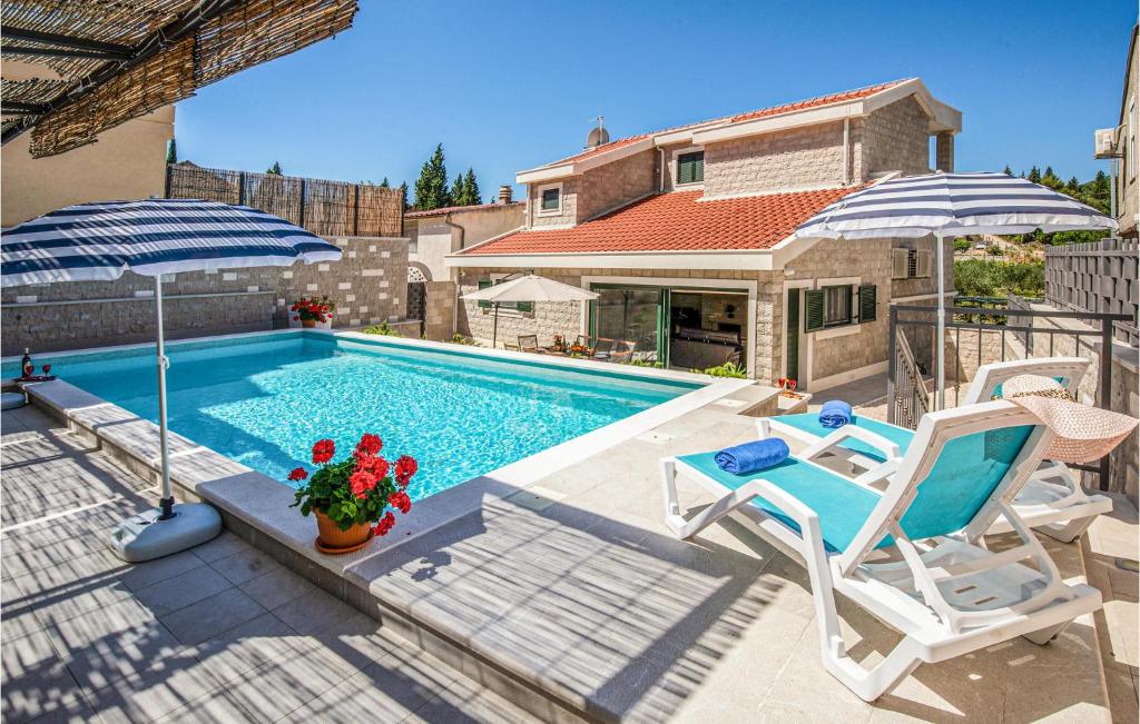 einen Pool mit 2 Stühlen und einem Sonnenschirm in der Unterkunft Beautiful Home In Klek With House A Panoramic View in Klek