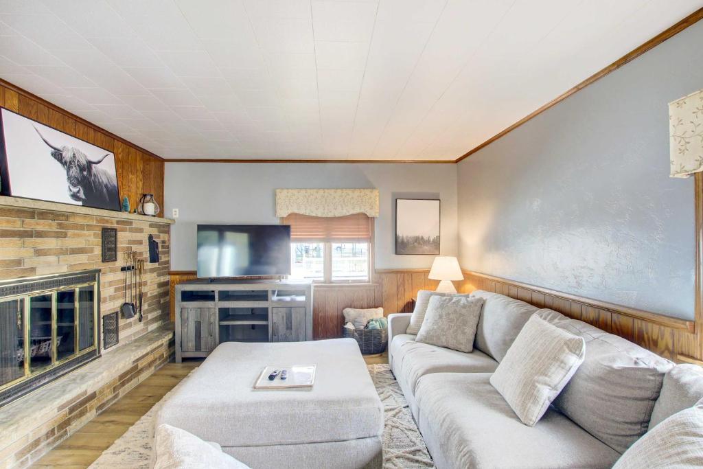 a living room with a couch and a tv at Cozy Wisconsin Abode Walk to Lake Michigan! in Algoma