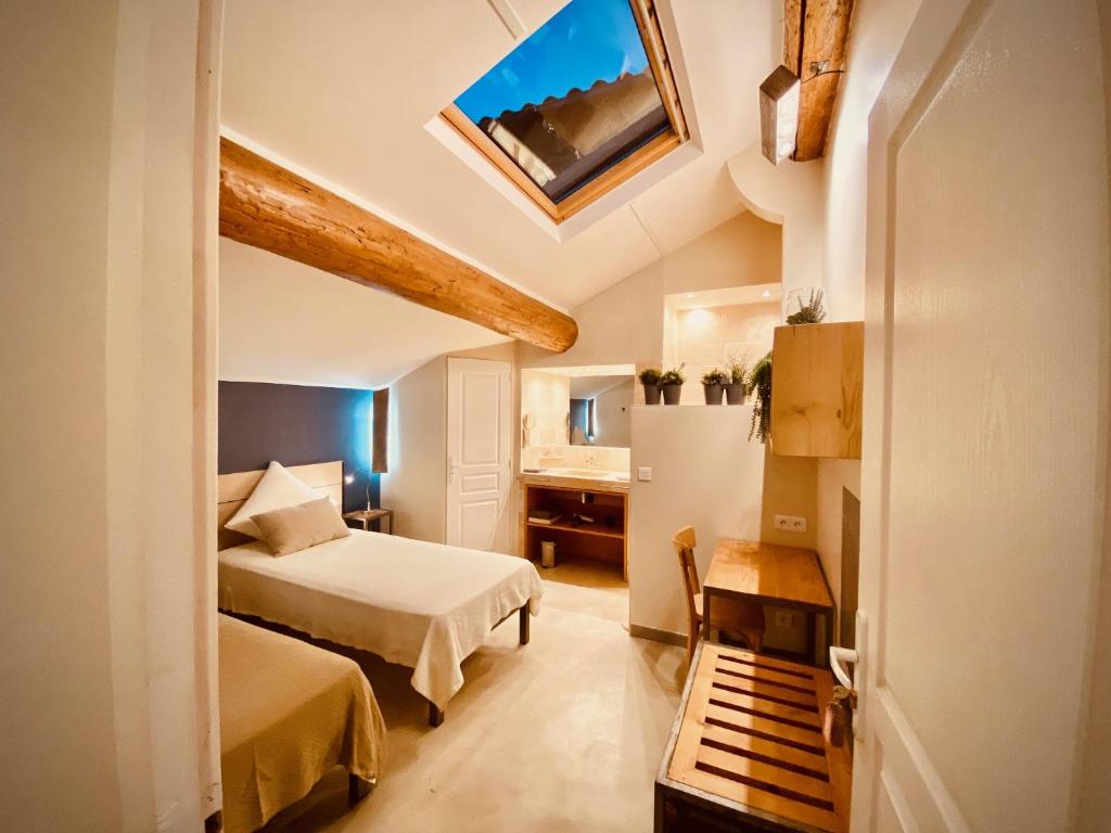 Una habitación de hotel con dos camas y una ventana. en L'atelier B&B, en Bédoin