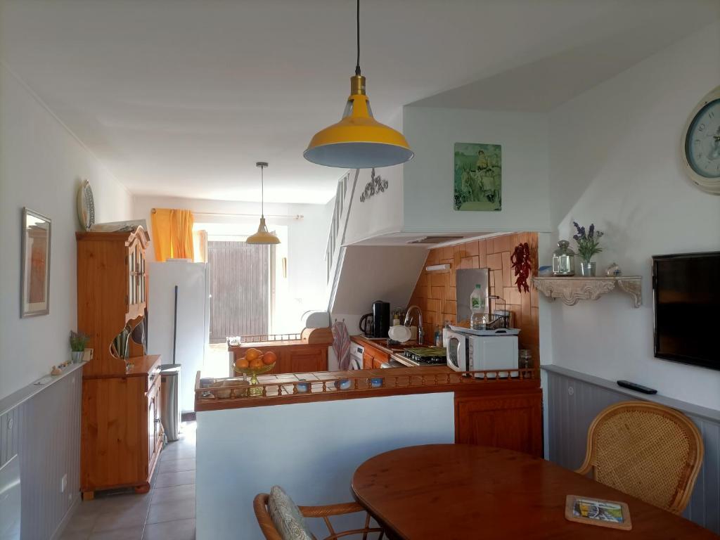une cuisine avec une table en bois et une cuisine avec une table à manger dans l'établissement Maison paisible avec parking, à Montpezat-de-Quercy