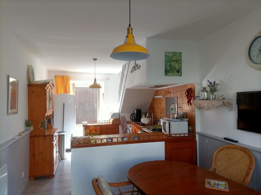 a kitchen with a wooden table and a kitchen with a tableablish at Maison paisible avec parking in Montpezat-de-Quercy