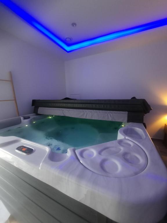 einen Whirlpool in einem Zimmer mit blauen Lichtern in der Unterkunft Loft Spa Led & bo in Thaon-les-Vosges