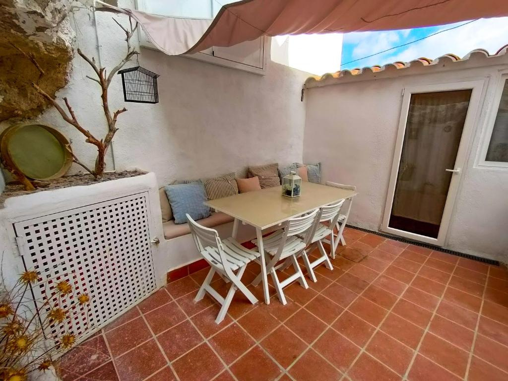 een tafel en stoelen op de patio van een huis bij La Cueva Blanca in Alcalá del Júcar