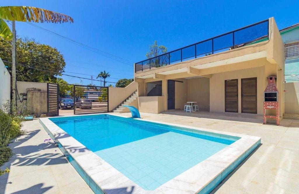 a swimming pool in front of a house at Flat Terreo n1 Porto de Galinhas c Piscina in Porto De Galinhas