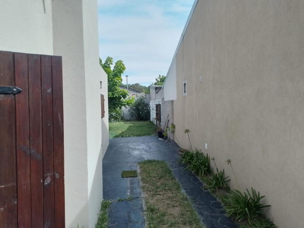 un callejón entre dos edificios con una puerta roja en Casa en ostende pinamar en Ostende