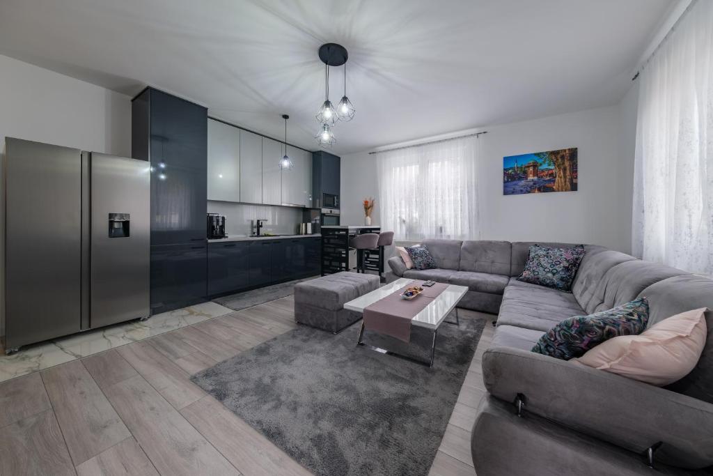 a living room with a couch and a kitchen at Apartment Aida in Sarajevo