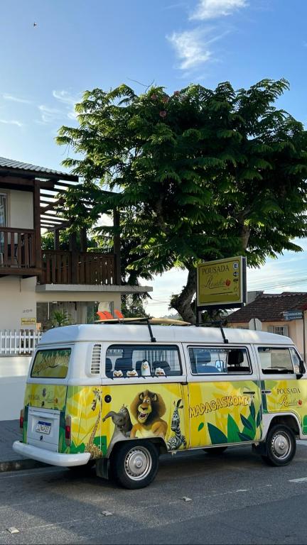 a yellow and white van parked on a street at Pousada Rosália in Penha