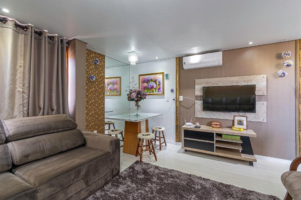 sala de estar con sofá y TV de pantalla plana en Solar da Encosta - Stay House Temporada, en Gramado