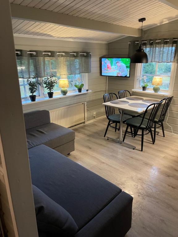 salon ze stołem, krzesłami i telewizorem w obiekcie Kvarnsjöns Naturcamping w mieście Sjötofta