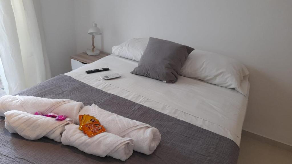 Una cama con dos toallas y un animal de peluche. en BL CALLE CATAMARCA en Corrientes