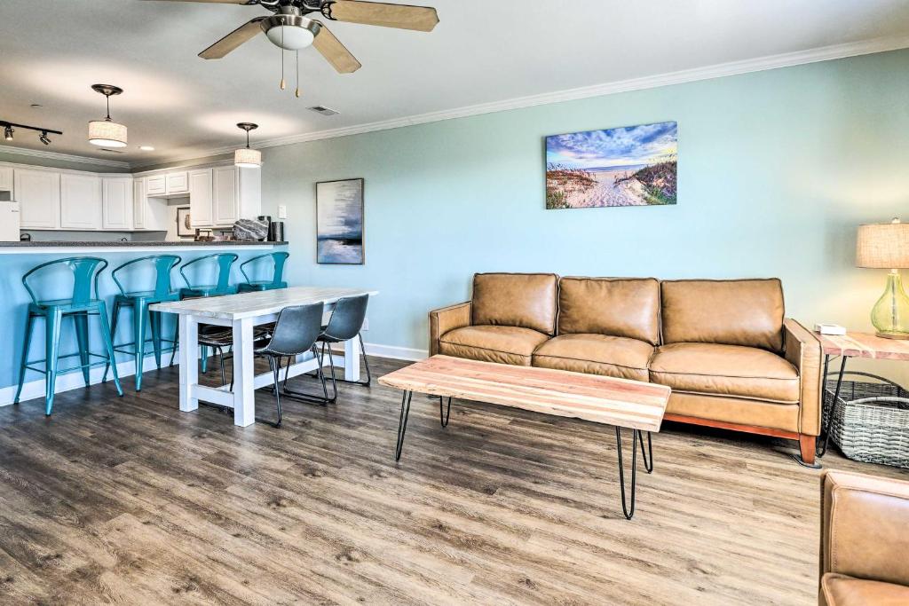 a living room with a couch and a table at Oak Island Condo - Walk to the Beach! in Oak Island