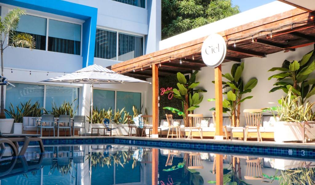 Hotel Blue Concept في كارتاهينا دي اندياس: مسبح الفندق مع الكراسي والمظلة