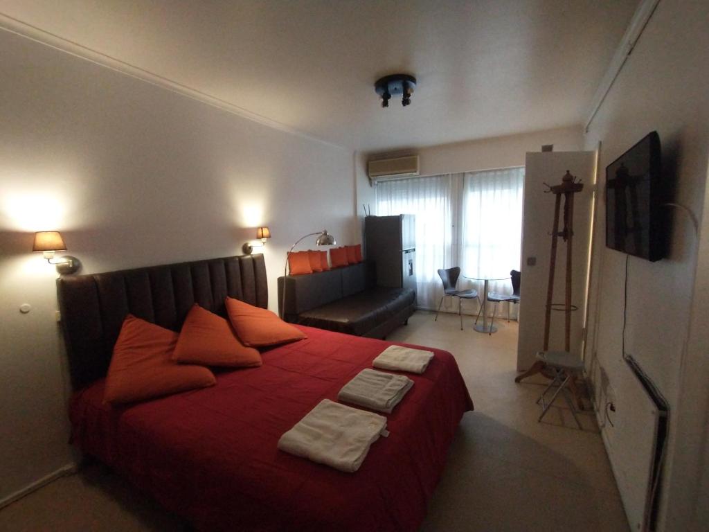 a bedroom with a large red bed with red pillows at Hermoso Apartamento en el centro de Buenos Aires. in Buenos Aires