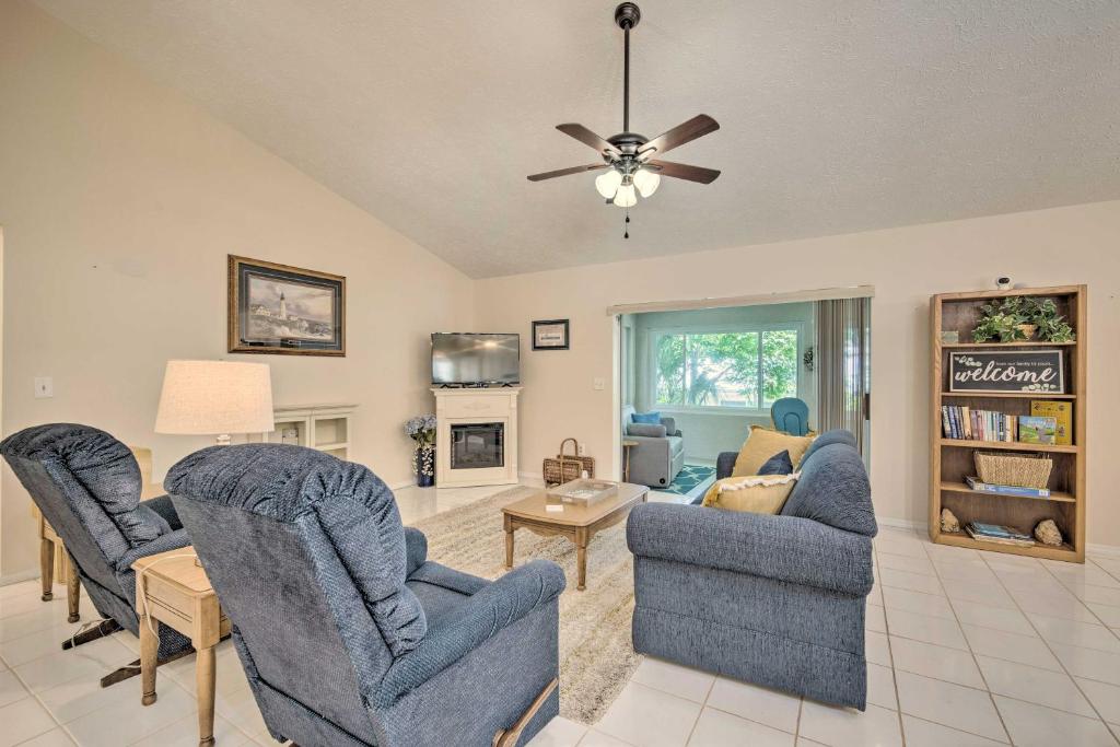 a living room with blue chairs and a ceiling fan at Crystal River Vacation Rental on Canal! in Crystal River