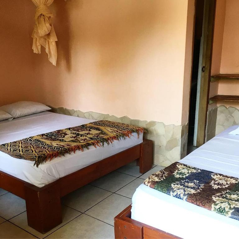 a room with two twin beds in it at Hostal Machalilla in Puerto López