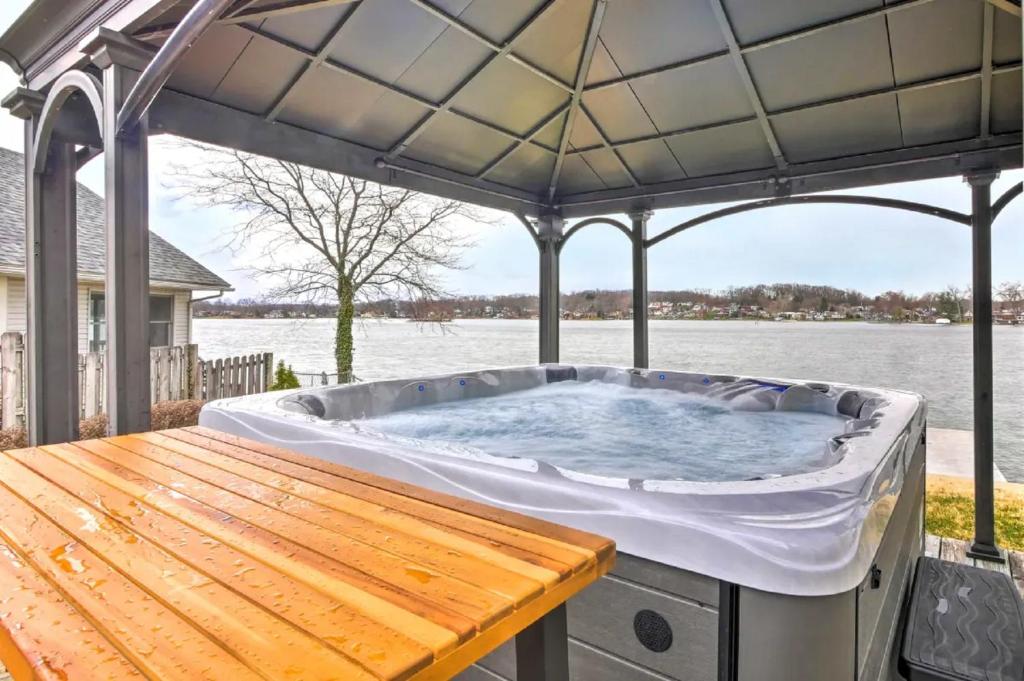 a hot tub on a deck with a table at New! The Docks @ Waterside - Lake Front Hot Tub! in Akron