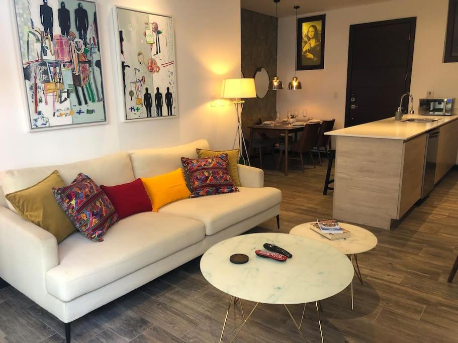 sala de estar con sofá y 2 mesas en L1B 202 - Boutique apartamento en Cayalá para 4 huéspedes, en Guatemala