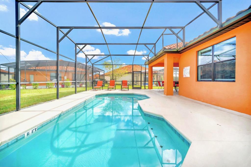 an indoor swimming pool in a house with an orange building at Upstay Bungalow w BBQ, Private Pool - By Disney in Davenport