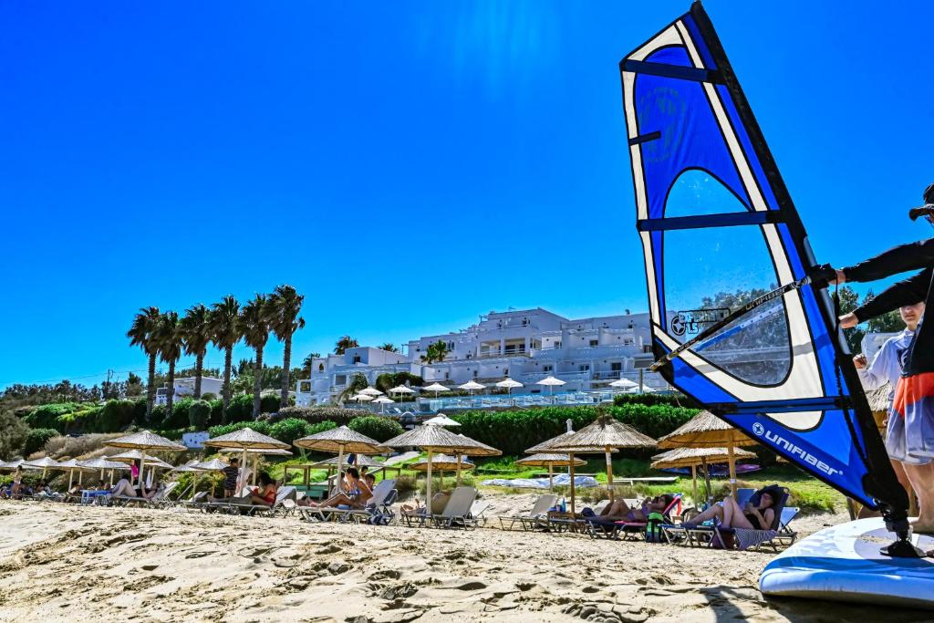 a beach with umbrellas and people sitting on the sand at Saint George Hotel in Chrissi Akti