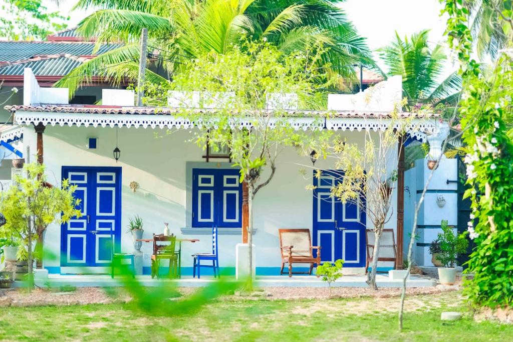 een huis met blauwe en witte deuren en bomen bij Sriyan Villa in Beruwala