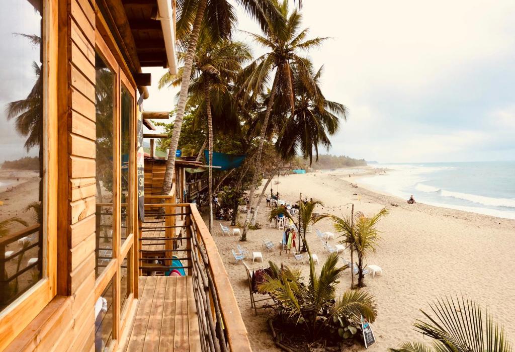 a view of the beach from the balcony of a beach house at Mendihuaca Surf Camp in Guachaca