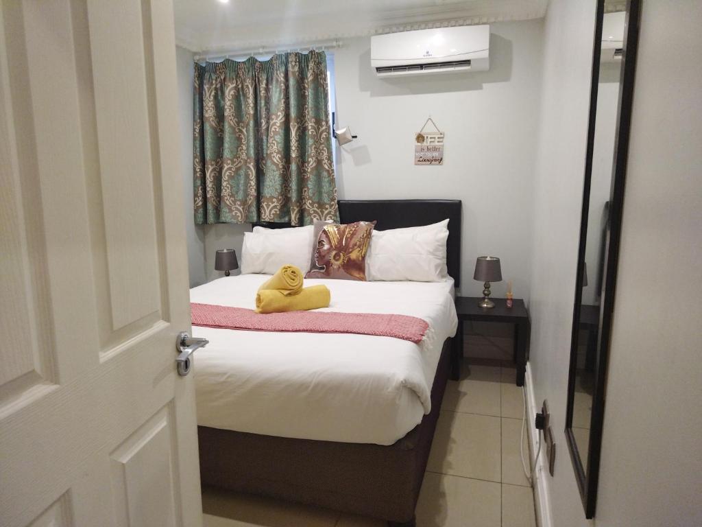 ダーバンにあるSails Luxury 1 Bedroom Apartmentのベッドルーム(黄色のテディベア付)