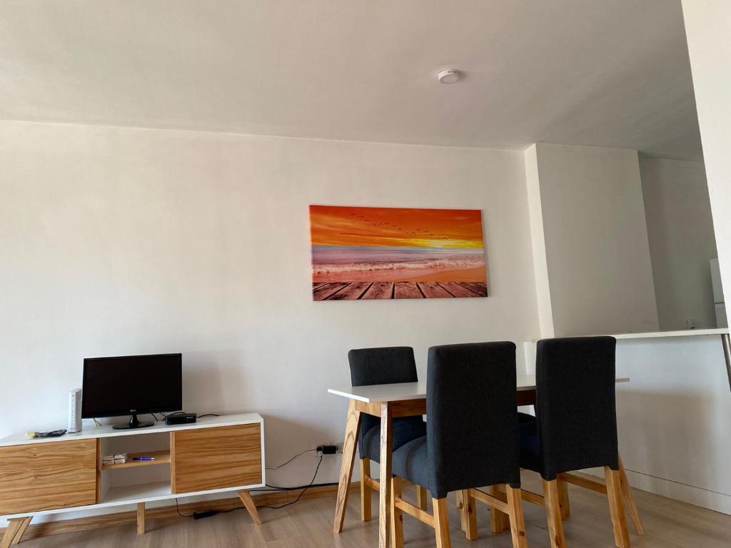 ein Zimmer mit einem Tisch mit Stühlen und einem Fernseher in der Unterkunft Departamento en Caballito in Buenos Aires