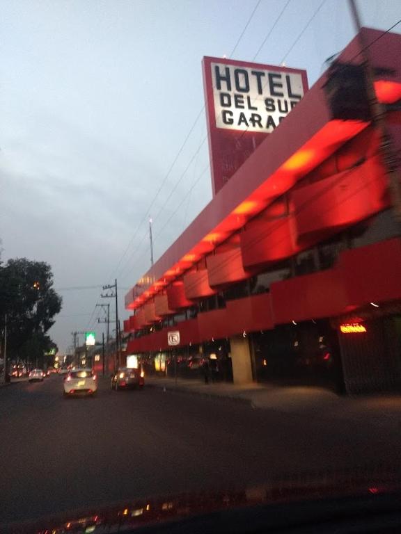 eine Hotel-Tankstelle, durch die Autos eine Straße entlangfahren in der Unterkunft Hotel del Sur in Mexiko-Stadt