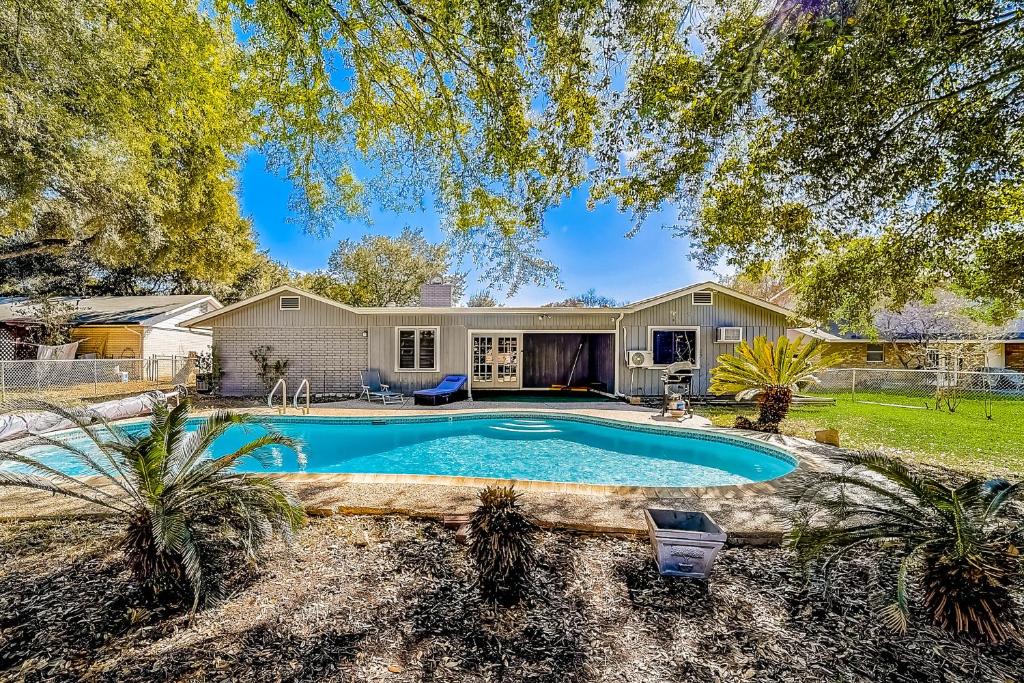 uma casa com uma piscina em frente a uma casa em Texas Dreams em San Antonio