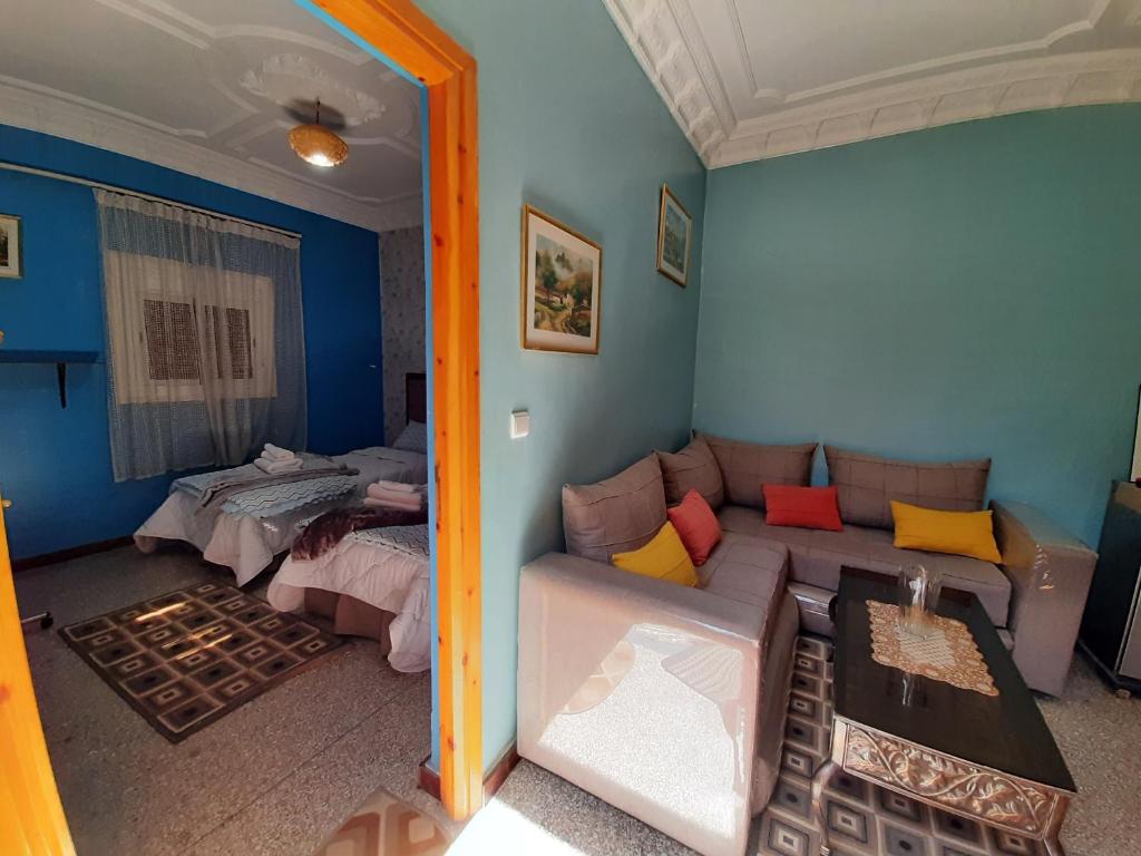 een woonkamer met een bank en een bed bij DARKOM in Dakhla