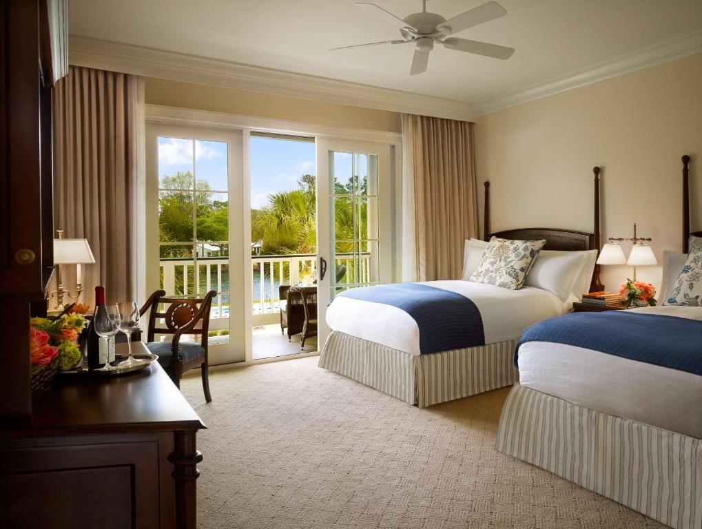 a hotel room with two beds and a balcony at Montage Palmetto Bluff in Bluffton