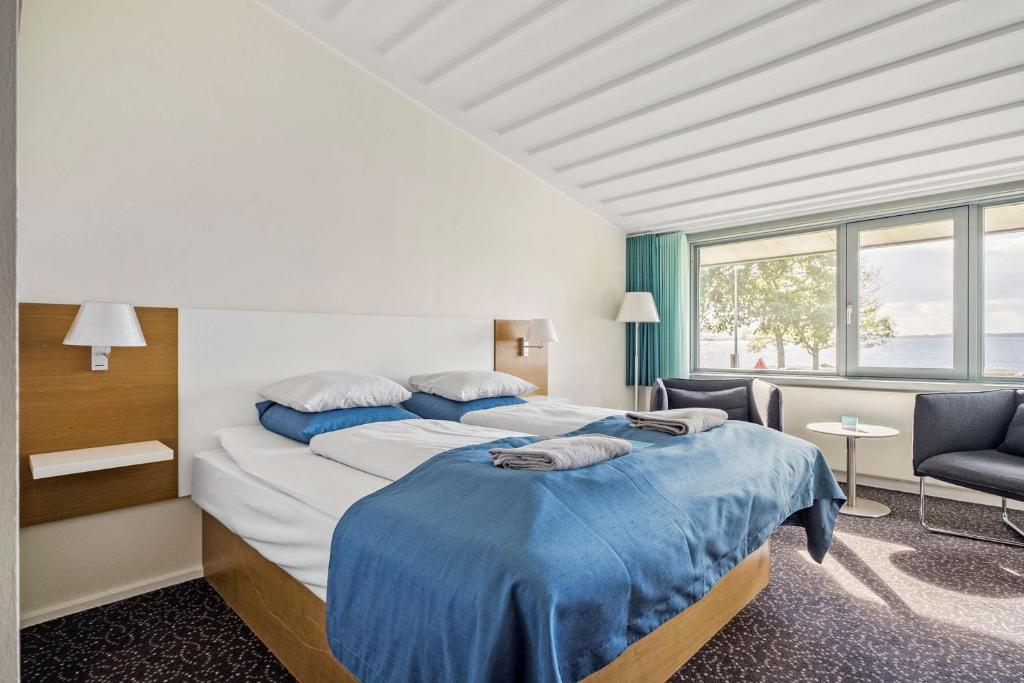 a hotel room with two beds and a window at Hotel Sonderborg Strand; Sure Hotel Collection by Best Western in Sønderborg
