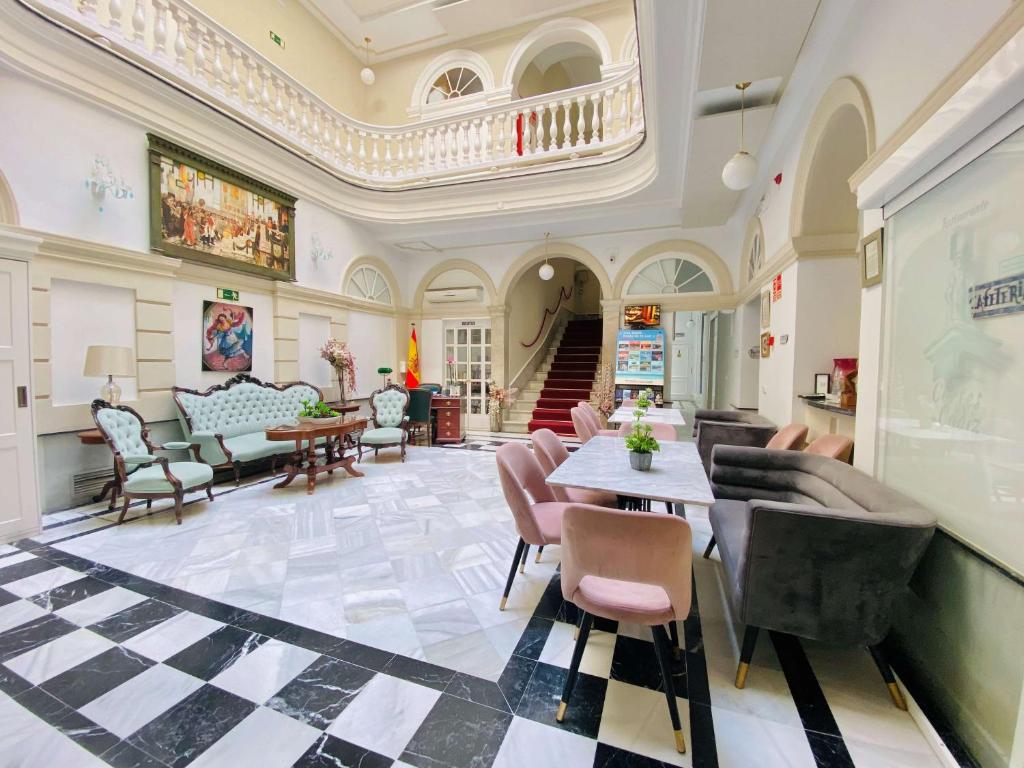 ein Wohnzimmer mit einem Tisch und Stühlen in der Unterkunft Hotel Las Cortes De Cádiz in Cádiz