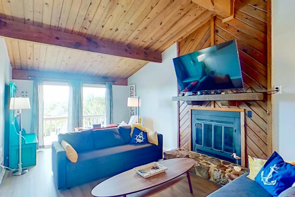 大西洋海灘的住宿－Carolina Coasting，客厅设有蓝色的沙发和壁炉