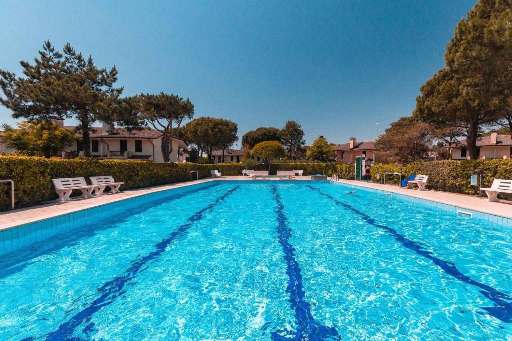 une grande piscine d'eau bleue dans l'établissement Holiday Homes in Porto Santa Margherita 43919, à Porto Santa Margherita