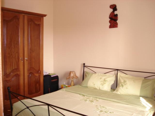 1 dormitorio con 1 cama con marco negro en Délices Chez l'Habitant Diack, en Dakar