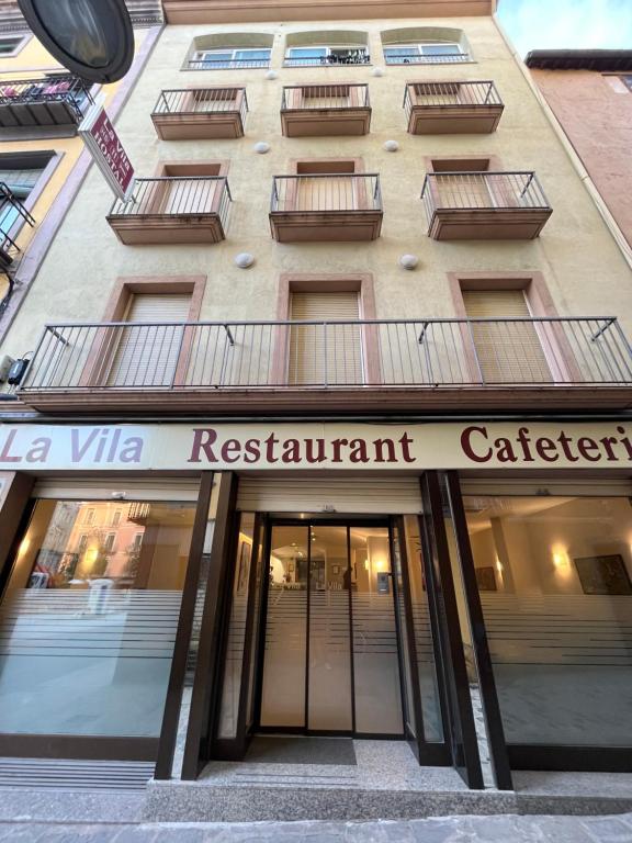 a building with a sign that reads restaurant cafeteria at Hostal La Vila in Olot