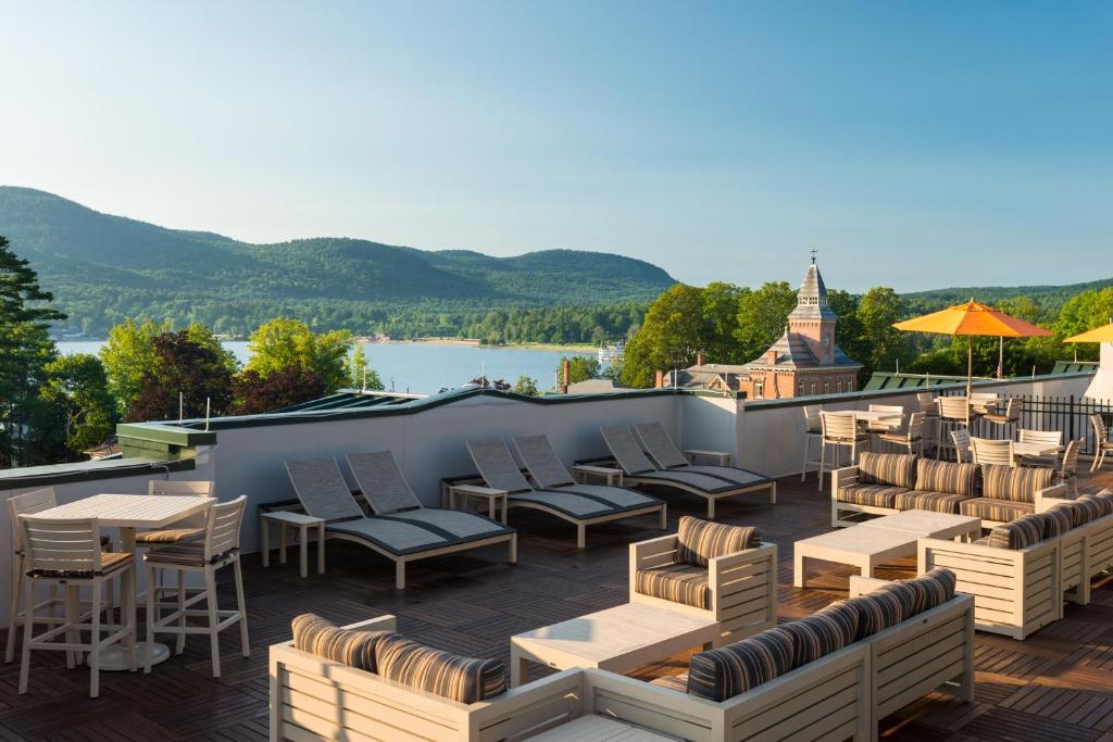 a patio with chairs and tables on a roof with a view at Courtyard by Marriott Lake George in Lake George