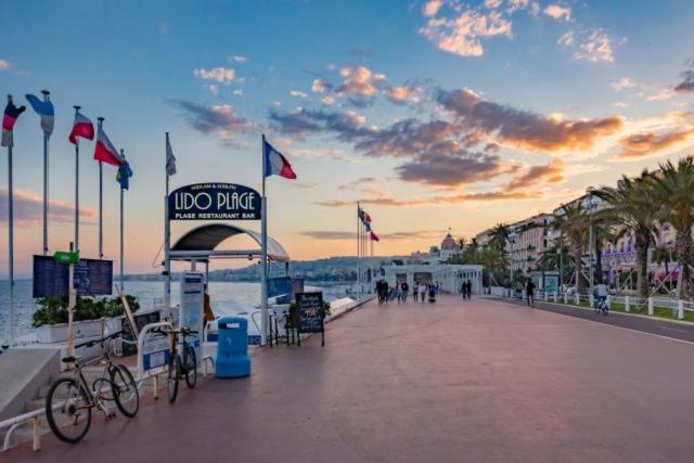 un paseo marítimo con un cartel en la playa con banderas en NICE City-Center 80m to the SEA / BEACH, en Niza